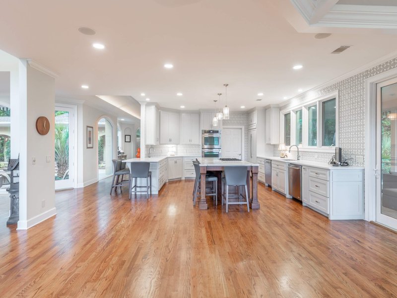 white living cabinets on a brown hardwood floor from Budget Flooring & Shutters in Las Vegas, NV